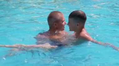Happy Smiling Father with Son Swim in Open Transparent Swimming Pool. Close up