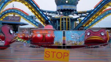 Slow Spinning, Stopping Carousel of Octopus in an Amusement Park. 4K. Close up.