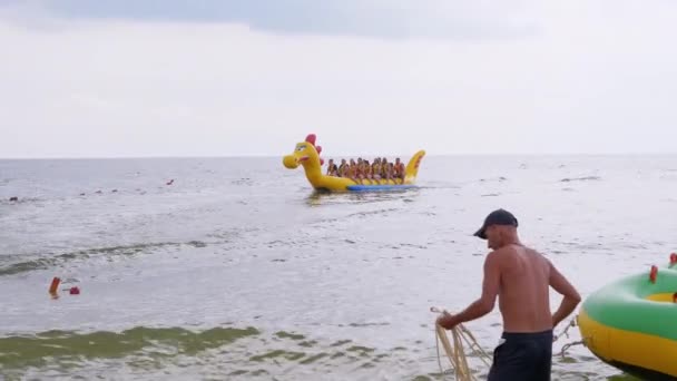 Happy Tourists in Life Jackets Ride an Inflatable Banana, a Dragon in the Open Sea — 비디오