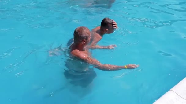 Happy Smiling Father with Son Swim in Open Transparent Swimming Pool. Close up — Stock video