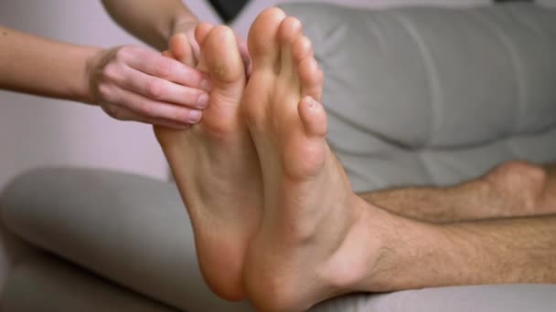 Γυναικείο μασάζ στα χέρια Αρσενικά πόδια, πόδια, σόλες. Κλείσε. Εστίαση — Αρχείο Βίντεο
