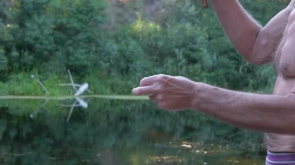 渔夫拿着一个旧竹竿,把一个面包球挂在钓钩上.4K — 图库视频影像