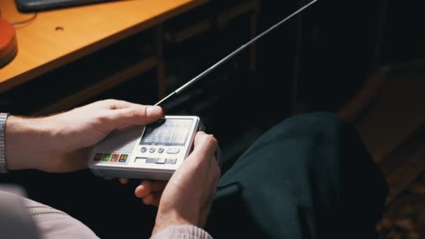Egy férfi rádiófrekvenciát hangol egy kis vevőkészülékre egy antennával. 4K. Közelről. — Stock videók