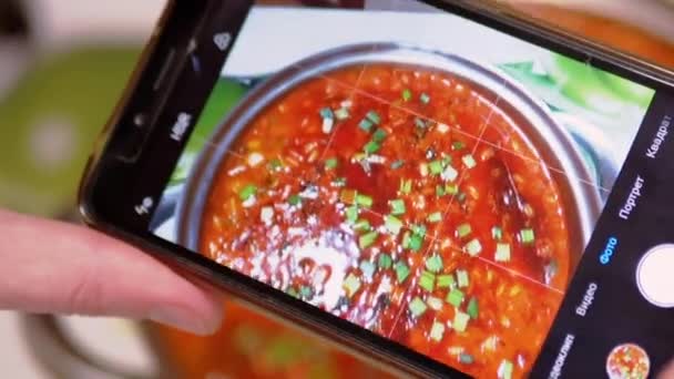Vrouwelijke handen nemen van een foto op een smartphone Traditionele Oekraïense Rode Borscht — Stockvideo