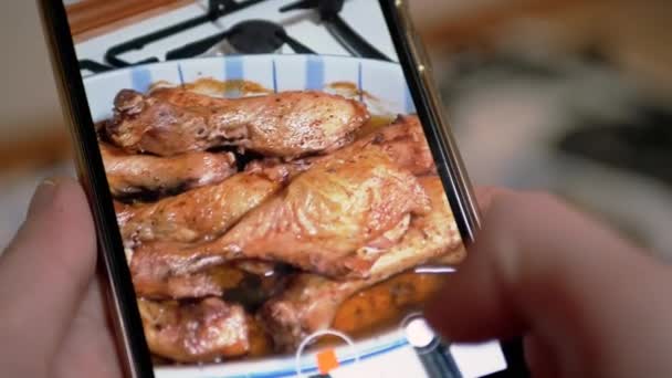 Kobiece ręce nagrywają wideo z gotowanym pieczonym kurczakiem na smartfonie. — Wideo stockowe