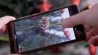 Kadın Eller, akıllı telefondan Noel Ağacı 'nın videosunu çekiyor. Kapat.