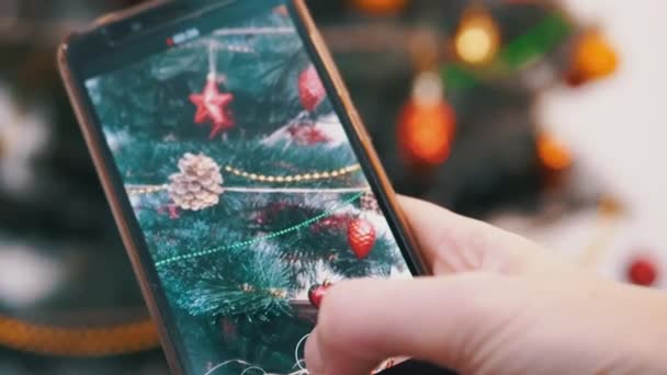Ženské ruce natáčí video vánočního stromu na smartphonu. Zavřít — Stock video