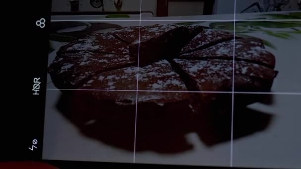 Kvinnliga händer Ta en bild av en chokladpaj i köket på en smart telefon. Zoom — Stockvideo