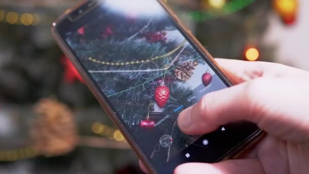 女性の手はスマートフォンでクリスマスツリーのビデオを撮影しています。閉じろ! — ストック動画