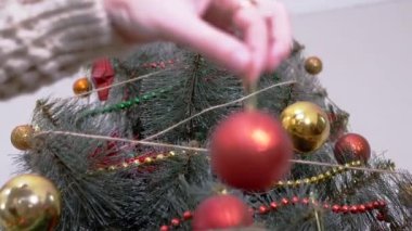 Kadın Eller Noel Ağacı 'nı Noel süsleriyle süslüyor. Büyüt