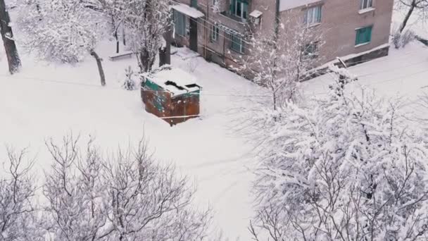 住宅用レンガ造りの家の雪に覆われたヤードにある古いラスティガレージ — ストック動画