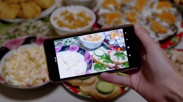 Las manos femeninas toman fotos, videos de comida de mesa de año nuevo en un teléfono inteligente. 4K — Vídeos de Stock