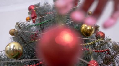 Kadın Eller Noel Ağacı 'nı Noel süsleriyle süslüyor. Büyüt