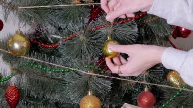 Kadın Eller Noel Ağacı 'nı Noel süsleriyle süslüyor. Büyüt