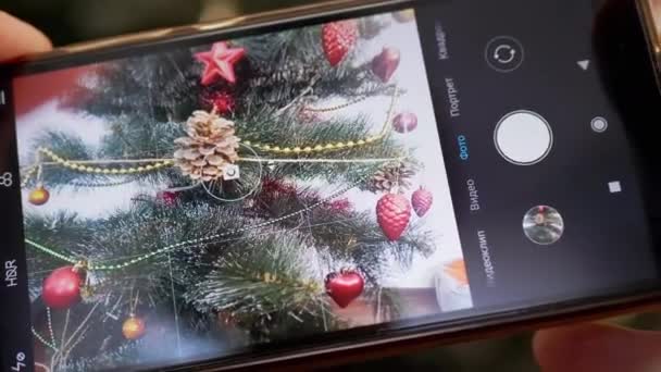 Γυναικεία χέρια Τραβώντας μια φωτογραφία του χριστουγεννιάτικου δέντρου σε ένα έξυπνο τηλέφωνο. 4K. Κλείσε. — Αρχείο Βίντεο