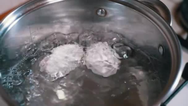 Zwei Eier kochen in einem Topf mit kochendem Wasser. Zeitlupe. Nahaufnahme — Stockvideo