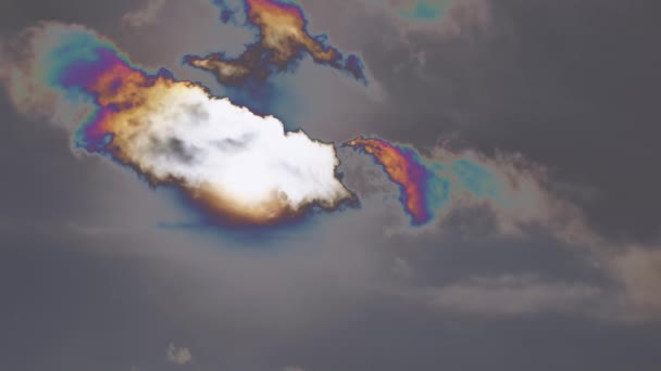 Nubes multicolores iridiscentes se mueven lentamente sobre los rayos ocultantes del sol. — Vídeo de stock