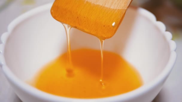 Tangan Stirs dengan Wooden Spatula, Ladle Yellow Thick Honey in a Bowl. Tutup. — Stok Video