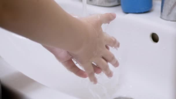 Dziecko myje ręce pod bieżącym strumieniem wody w zlewie w łazience. 4K — Wideo stockowe