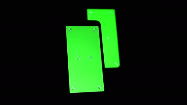 Dos teléfonos inteligentes con una pantalla verde, clave de croma, marcadores en un fondo negro — Vídeos de Stock