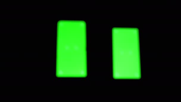 暗い部屋でスマートフォンの緑の画面による手のスライドの黒いシルエット — ストック動画