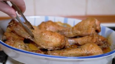 Bir Kadın Sulu Tavuk Bacağı 'nı Tong' la ısıya dayanıklı bir forma sokuyor. 4K