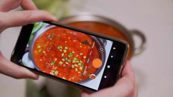 Vrouwelijke handen zijn het opnemen van een video van de Oekraïense Rode Borscht op een smartphone. — Stockvideo