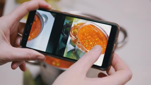 A Woman Looks Photo of Traditional Ukrainian Red Borscht in a Smartphone — Stok Video