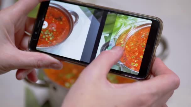 A Woman Looks at a Photo of Traditional Ukrainian Red Borscht on a Smartphone — Stock Video
