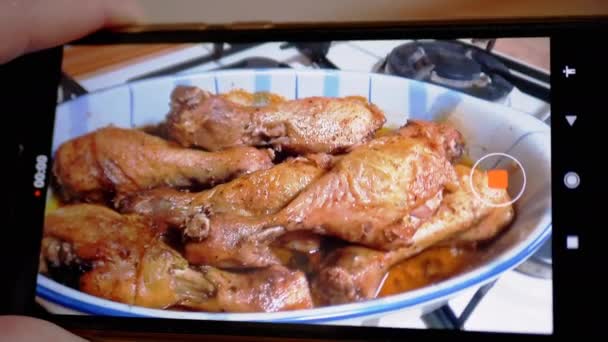 Vrouwelijke handen zijn het opnemen van een video van gebakken gebraden kip op een smartphone. — Stockvideo
