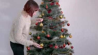 Kadın Eller Noel Ağacı 'nı Noel süsleriyle süslüyor. Büyüt