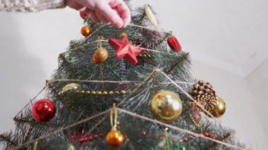 Dişi Eller Noel ağacına kırmızı yıldız asıyor. Alt Manzara. Görüntü. 4K