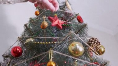 Dişi Eller Noel ağacına kırmızı yıldız asıyor. Alt Manzara. Görüntü. Büyüt