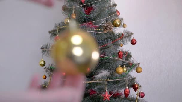 Female Hands Decorate Christmas Tree with New Year Christmas Decorations. 4K — Stock Video