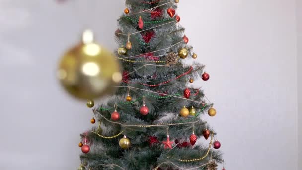 Las manos femeninas decoran el árbol de Navidad con decoraciones navideñas de año nuevo. Zoom: — Vídeo de stock