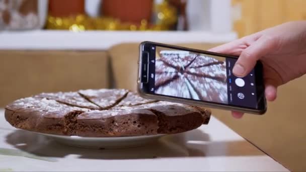 Γυναικεία χέρια Τραβώντας μια φωτογραφία μιας πίτας σοκολάτας στην κουζίνα σε ένα Smart Phone. Εστίαση — Αρχείο Βίντεο