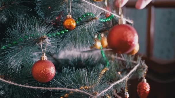 As mãos femininas decoram a árvore de Natal com decorações de Natal de Ano Novo. 4K — Vídeo de Stock