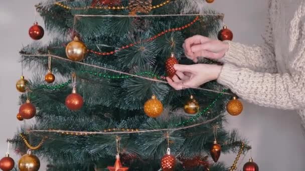 Żeńskie Dłonie Udekoruj choinkę noworocznymi dekoracjami świątecznymi. Powiększenie — Wideo stockowe