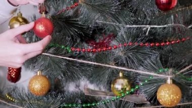 Kadın Eller Noel Ağacı 'nı Noel süsleriyle süslüyor. Büyüt