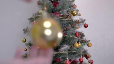 Kadın Eller Noel Ağacı 'nı Noel süsleriyle süslüyor. Büyüt