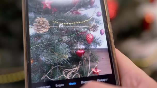 女性的手在智能手机上为圣诞树拍照。4K 。靠近点 — 图库视频影像