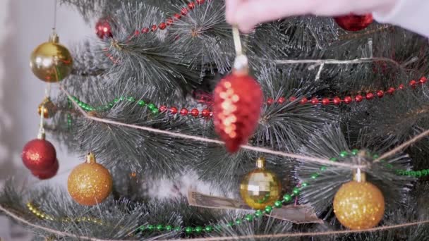 Female Hands Decorate Christmas Tree with New Year Christmas Decorations. 4K — Stock Video