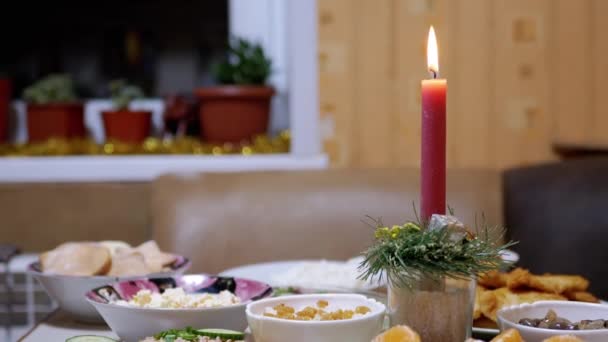 En brinnande röd jul ljus brinner med en ljus låga på nyårsbordet — Stockvideo