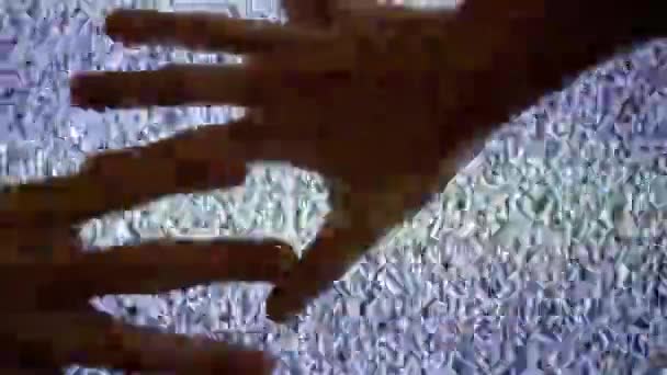 Duas mãos rastejantes deslizam pela tela de uma TV antiga que não tem sinal. 4K — Vídeo de Stock
