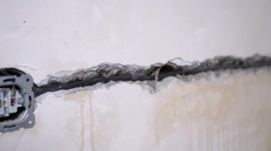 Elektrik kablolarını döşemek, iç duvardaki bir deliğe soket yerleştirmek.