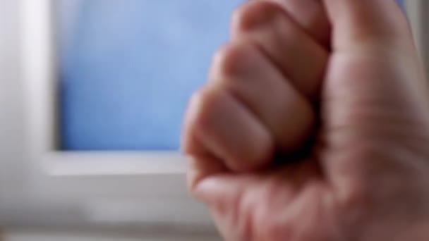 Злой мужчина показывает кулак на заднем плане мерцающего телевизионного экрана без сигнала. 4K — стоковое видео