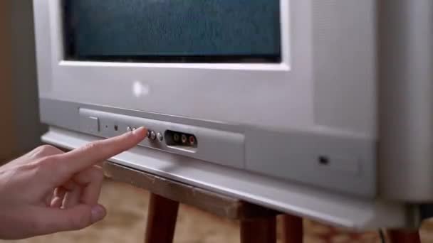 Una mano masculina presiona los botones con el dedo en la vieja televisión vintage con interferencia — Vídeos de Stock