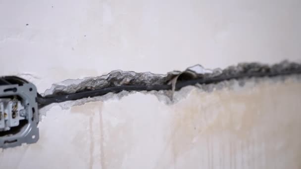 Lägga elektriska ledningar, Installera ett uttag i ett hål i väggen i interiören — Stockvideo