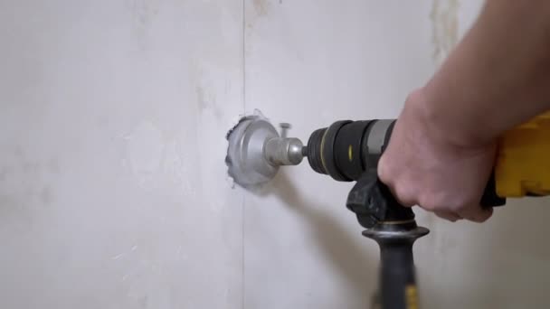 펜 처를 사용하는 건축가가 콘크리트 벽 속에 구멍을 만들어 전력 소켓을 설치하다 — 비디오