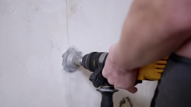 Руки будівельника свердлити отвір у стіні з перемикачем для встановлення гнізда . — стокове відео